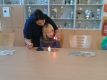 Melanie zeigt, wie im Beisein eines Erwachsenen eine Kerze richtig angezündet wird.